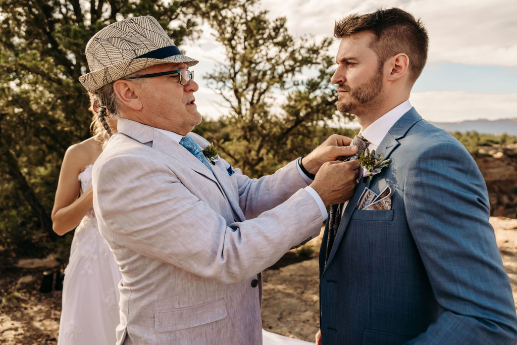 father in law of the groom helping him with his tie